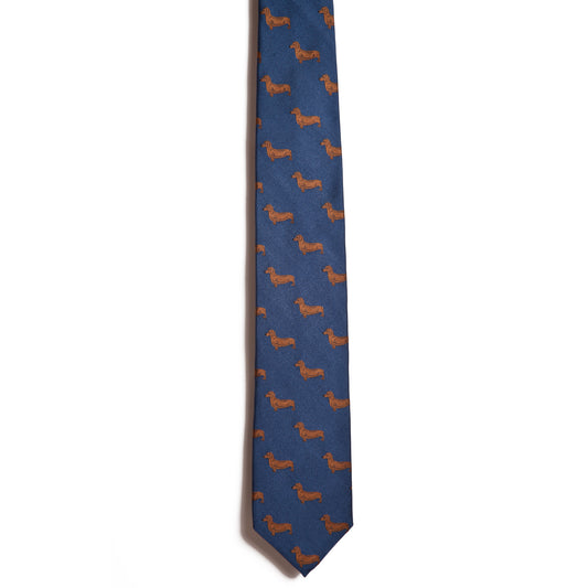 A blue necktie by Alden Madison features an elegant jacquarded pattern of small brown Shorthaired Dachshund dogs woven throughout the fabric.